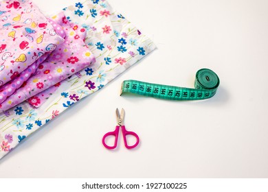 Creative hobby sewing colurful textile scissors and measuringtape sewing centimeter, Top view sewing accessory or tailor equipment, flatlay pink material flower print girly children white background