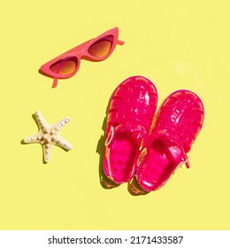 Creative Holiday Concept. Jelly Sandals, Sunglasses And Starfish On Yellow Background. Minimal Summer Composition.