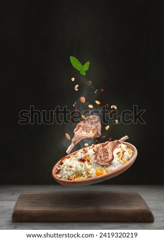 Creative idea arabian Kabsa- Rice with lamb ribs, cashew, almonds, raisin- Falling on Bowl- Food levitation concept-copy space-black background