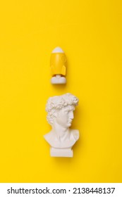 Creative idea concept. David's bust with a rocket on a yellow background