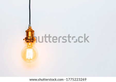 Creative idea concept, designer lamp, modern interior item. Vintage fashionable edison lamp on light gray background. Top view flat lay copy space. Lighting, electricity, background with lamp