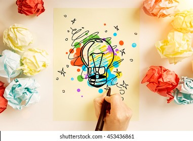 Creative Idea Concept With Hand Drawing Abstract Lightbulb Sketch On Paper Sheet Surrounded With Colorful Crumpled Paper Balls