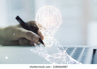 Creative idea concept with light bulb illustration and hand writing in notebook on background with laptop. Multiexposure