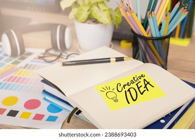 Creative Idea concept: Light bulb arranged with notebooks and post-it in the designer's desk space