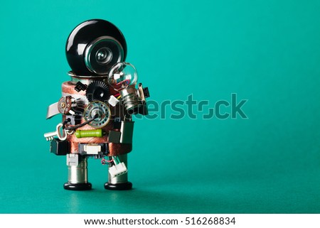 Creative idea concept. Robot looking at light bulb. retro style toy character with funny black helmet head. Copy space, green background