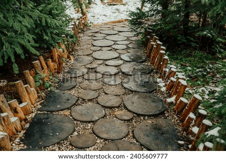 Creative idea for garden paths made of wood, log cabin. Winter nature.