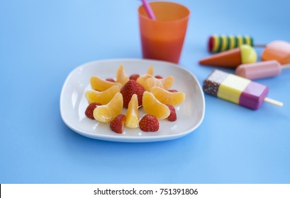 Creative Idea For Healthy Fruit Kid Snack Or Afternoon Break, Orange, Strawberry And Fresh Orange Juice With Colour Wooden Toys,Top View Of Healthy Food For Children At Tea Time Or Snack After School