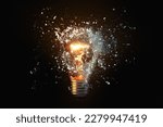 Creative idea light bulb explodes with shards of glass against a dark background. Business, ideas and new thinking, concept. Think Different. Go beyond what is possible.
