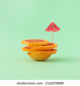 Creative idea made of grapefruit slices with umbrella on pastel background. Summer tropical fruit concept. - Shutterstock ID 2162078089