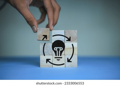 Creative idea, solution and innovation concept. Idea generation for business development. Wooden cube blocks with light bulb and cycle icons on clean background and copy space
