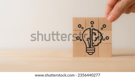 Creative idea, solution and innovation concept. Idea generation for business development. Wooden cube blocks with light bulb and gear icons on clean background and copy space.