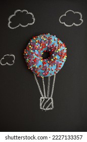 creative image of a bright donut and balloon drawing with chalk on a blackboard - Shutterstock ID 2227133357