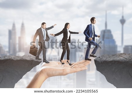 Creative image of team helping each other walk through obstacle on abstract city background with cliff gap. Teamwork, help, success and union concept