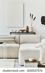 Creative interior composition of cozy living room with mock up poster frame and structure painting, corner sofa, coffee table, textile and personal accessories. Scandinavian classic style.
