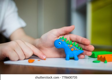 Creative kid molding at home. child play with plasticine. child sculpts a dinosaur  - Powered by Shutterstock