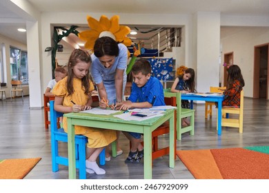 Creative kids during an art class in a daycare center or elementary school classroom drawing with female teacher. - Powered by Shutterstock