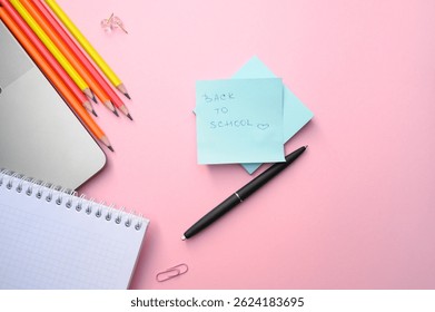 Creative layout with "Back to School" note, colorful pencils, and notebook on pink desk. Perfect for academic ads, school start campaigns, and education.