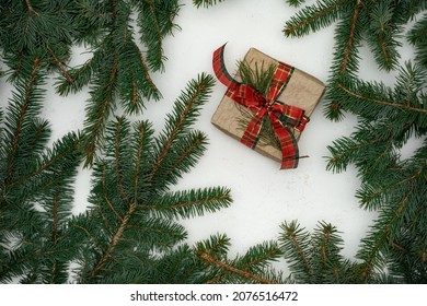 Creative layout from branches of a Christmas tree. View from above. Nature New Year concept, Merry Christmas greetings. Empty space for text. Gift. Red ribbon.