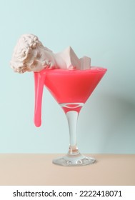 Creative layout, cocktail glass with neon slime and David bust on two tone pastel background. Visual trend. Minimalistic aesthetic still life.