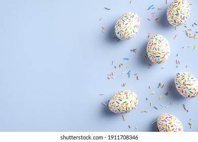 Creative layout with colorful Easter eggs on blue background. Happy Easter banner mockup. Minimal style. Flat lay, top view. - Shutterstock ID 1911708346