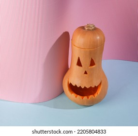 Creative Layout Composition Of Halloween Pumpkin On Blue Pink Background With Shadow. Face With Sinister Smile. Trick Or Treat