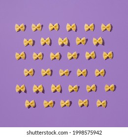 Creative Layout Of Homemade Farfalle. Fun And Bright Food Concept. Italian Pasta On Purple Background.