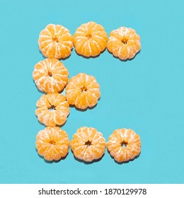 Creative Layout Of The Letter E From Peeled Tangerines On A Blue Background. Flatlay.