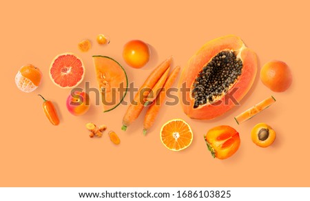 Creative layout made of carrot, papaya, orange, grapefruit, apricot, melon, tangerine , curcuma, and pepper on the orange background. Flat lay. Food concept. Macro  concept.