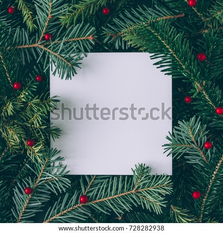 Creative layout made of Christmas tree branches with paper card note. Flat lay. Nature New Year concept.
