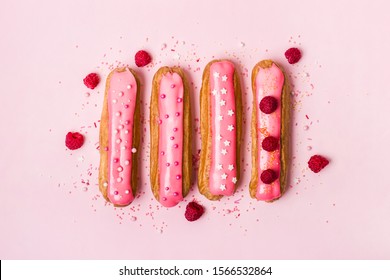 Creative Layout Made Of Eclairs With Pink Glaze On Pink Background. Monochrome Food Concept.