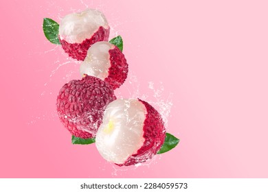 Creative layout made from Fresh lychee or litchi fruit and water splashing on a pastel pink background. Fruit minimal concept and copy space.