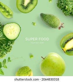 Creative layout made of  kiwi, cucumber, apple, kale and green peas on the green background. Flat lay. Food concept. Macro  concept.