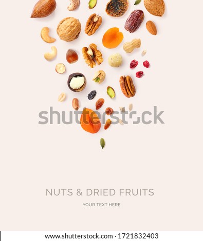 Creative layout made of macadamia, hazelnuts, walnut, cashew, sunflower seeds, peanut, almond, dates, pecan, fig, pumpkin seeds, pistachio, raisin,  cranberry on the beige background. Food concept.