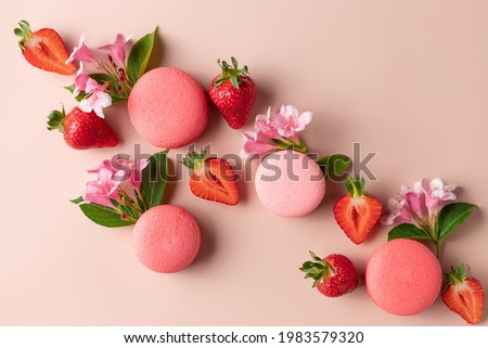 Creative layout made of macaroons, strawberries, flowers on pink background. flat lay. summer background