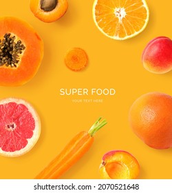 Creative layout made of  papaya, orange, carrot, grapefruit and apricot on the orange background. Flat lay. Food concept. Macro  concept.