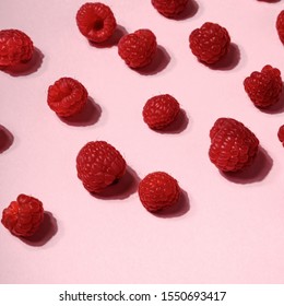 Creative layout made of raspberry berry in hard light on colorful pink background. Hard shadow, minimal flat lay style. Food concept. Fruit pattern top view. Arkistovalokuva