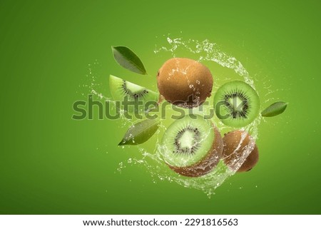 Creative layout made from Sliced of kiwi and water Splashing on a green background.
