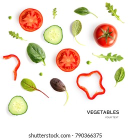 Creative layout made of tomato, cucumber and salad leaves on the white background. Flat lay. Food concept. 