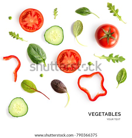 Creative layout made of tomato, cucumber and salad leaves on the white background. Flat lay. Food concept. 