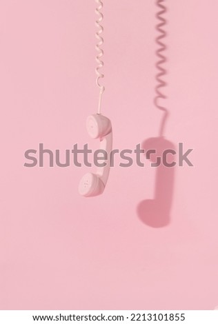 Creative layout with pink retro phone handset on pastel pink background. 80s or 90s retro fashion aesthetic telephone concept. Minimal romantic handset idea. Valentines day idea.