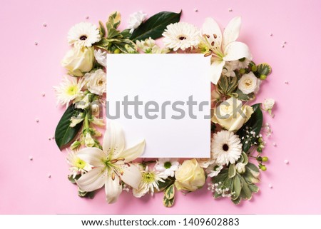 Creative layout with white flowers, square shape paper for copyspace over pink background. Top view, flat lay. Spring and summer concept