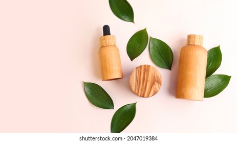 Creative Layout From The Wooden Cosmetics Containers With Fresh Green Leafs Around.Pretty Pastel Colors,natural Materials.Organic Concept.Large Banner With Copy Space.