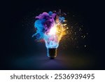 Creative light bulb explodes with colorful dry paint, sparks and splashes on a black background, concept. Think differently creative idea concept. Motion Color drop in water, Ink swirling