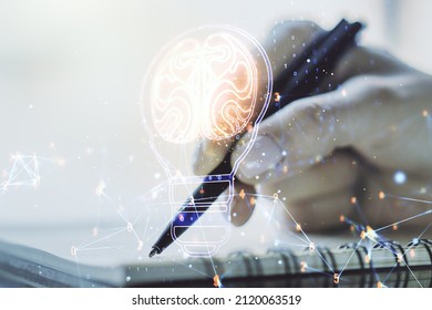 Creative light bulb with human brain hologram and with woman hand writing in notepad on background, artificial Intelligence and neural networks concept. Multiexposure