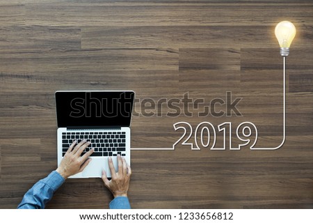 Creative light bulb idea 2019 new year, With businessman working on laptop computer PC, Top view from above