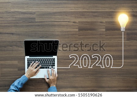 Creative light bulb idea 2020 new year, With businessman working on laptop computer PC, Top view from above