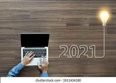 Creative light bulb idea 2021 new year, With businessman working on laptop computer PC, Top view from above - Shutterstock ID 1811434180