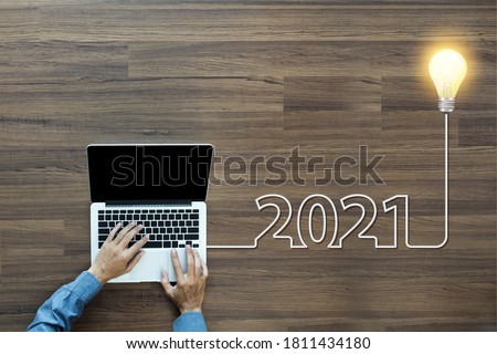 Creative light bulb idea 2021 new year, With businessman working on laptop computer PC, Top view from above