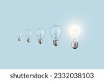 Creative light bulbs loading process and one glowing light bulb on a blue background. Creative idea, concept. Uploading a new idea. Project and success