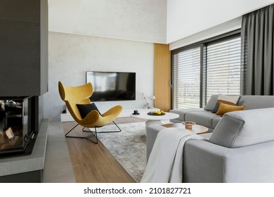 Creative living room interior composition with corner sofa,  yellow armchair, fireplace and personal accessories. Panoramic window. Template.